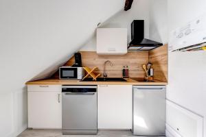 a kitchen with white cabinets and a counter top at Plein centre, 2 chambres, lumineux, "Traverse" in Sarlat-la-Canéda