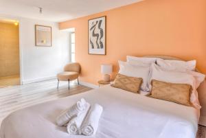 a bedroom with a large white bed with towels on it at Plein centre, 2 chambres, lumineux, "Traverse" in Sarlat-la-Canéda