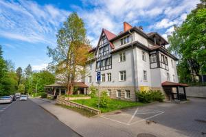 a large white building on the side of a street at Medical Sensus in Polanica-Zdrój