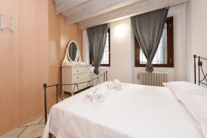 a bedroom with a white bed and a mirror at Domus Malvezzi in Centro Storico, 100m dal Lago & 4 Ospiti in Desenzano del Garda