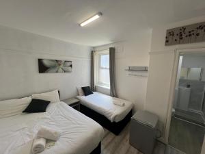 a small room with two beds and a window at Henson hotel in Blackpool