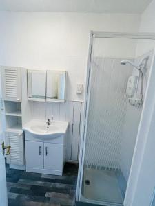 a white bathroom with a sink and a shower at Henson hotel in Blackpool