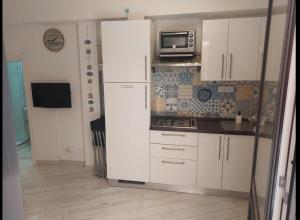 a kitchen with white cabinets and a microwave at La Casetta in Finale Ligure
