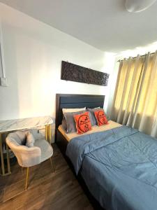 a bedroom with a bed and a chair and a desk at 2 Bedroom Condo Iloilo City in Iloilo City