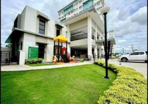 a white building with a yellow umbrella in the grass at 2 Bedroom Condo Iloilo City in Iloilo City