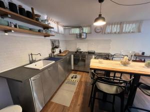 a kitchen with stainless steel appliances and a wooden table at Loft delle meraviglie in Vallecchia +5 photos