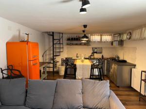a living room with a couch and a kitchen at Loft delle meraviglie in Vallecchia
