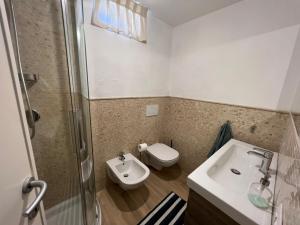 a bathroom with a toilet and a sink and a shower at Loft delle meraviglie in Vallecchia
