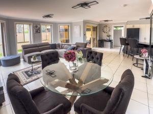 a living room with a glass table and chairs at Prestons Dream Holiday 4 Bedroom in Prestons