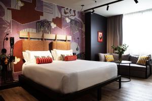 a bedroom with a large bed and a couch at Mercure Roma Cinecittà in Rome