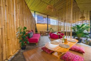 a living room with a table and a red couch at Let's Get Lost Ubud in Ubud