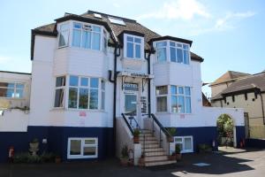 a white and blue house with blue windows at Littlestone Hotel in New Romney