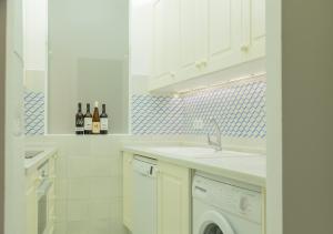 Una cocina blanca con fregadero y lavavajillas. en Apartamento Alvear, en Montilla