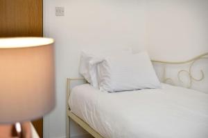 a white bed with white pillows on top of it at Host & Stay - Oxford Street House in Swansea