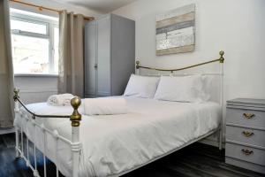 a bedroom with a white bed and a window at Host & Stay - Oxford Street House in Swansea