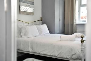 a bed with white sheets and pillows in a bedroom at Host & Stay - Oxford Street House in Swansea +42 photos