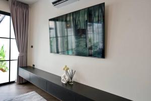 a living room with a large television on the wall at House 148 Patong Pool Villa 4BR Near Beach in Patong Beach