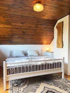 a bed in a room with a wooden ceiling at Chata Radužel in Bavorov +14 photos