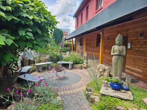 a garden with a statue in front of a building at Camping-Fass inklusive Sauna & Frühstück, Bad & WC über die Terrasse in Halle an der Saale