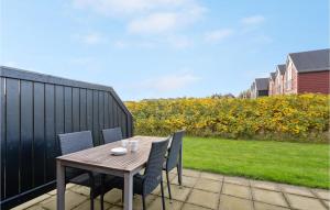 ein Holztisch und Stühle auf einer Terrasse in der Unterkunft Stunning Home In Nørre Nebel With Wifi in Nørre Nebel
