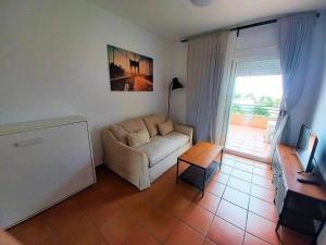 a living room with a couch and a table at Estudio Regency Alcaidesa in La Alcaidesa