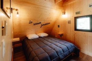 a room with a bed in a log cabin at LES CHALETS DE COYRON. in Coyron