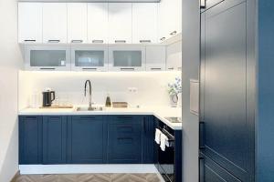 a kitchen with blue cabinets and a sink at "Петър 27" Апартамент До Плажа С Паркинг "Peter 27" Top Center And Private Parking in Burgas City +9 photos