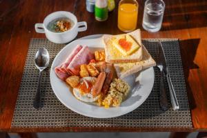 a plate of breakfast food on a wooden table at Kokotel Khao Lak Lighthouse in Khao Lak