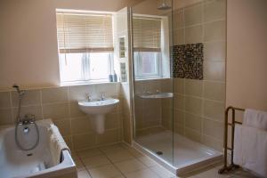 a bathroom with a tub shower and a sink at Applewood in Much Wenlock