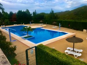 a large swimming pool with chairs and an umbrella at Estudio Regency Alcaidesa in La Alcaidesa +13 photos