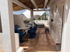 a patio with blue chairs and a table on a house at Fantastic Spanish villa with swimming pool in Sierra Golf, near Corvera airport in Murcia in La Tercia