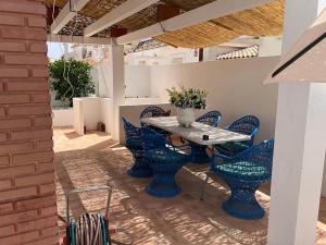 a patio with blue chairs and a table at Fantastic Spanish villa with swimming pool in Sierra Golf, near Corvera airport in Murcia in La Tercia