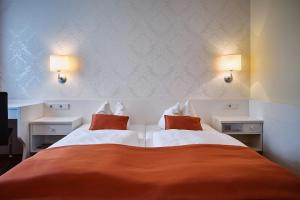 Un dormitorio con dos camas y dos luces en la pared. en Herdegen Rooms - Self Check-in, en Passau