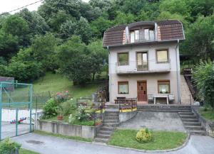 a small house with a balcony and a yard at Guesthouse Ema in Banja Luka