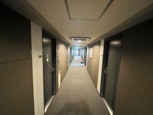 a hallway of an office building with a long corridor at Hotel Route-Inn Mitsukaido Ekimae in Joso