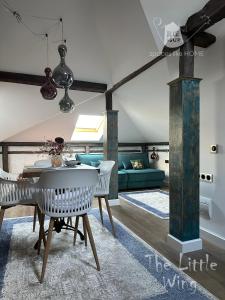 a living room with a table and chairs and a couch at Пространства за гости Синият час - апартамент Little Wing in Ruse