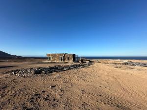an old building on the beach near the ocean at Casita Tahona con vistas de infarto al mar y volcanes con absoluta privacidad in Parque Holandes