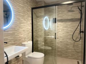 a bathroom with a toilet and a glass shower at Selecta Marbella Sentire Apartaments in Marbella