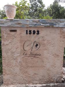Un cartel en una pared con un jarrón encima. en La Bergerie, en Lorgues 34 fotos más