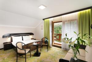 ein Hotelzimmer mit einem Bett und einem Tisch und Stühlen in der Unterkunft Hotel Zátiší in Špindlerův Mlýn