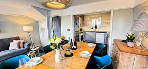 a living room with a wooden table and blue chairs at Harbour & Mountain Views, Porthmadog House, Sleeps 9, 4 Bedrooms, Two and Half Bathrooms in Porthmadog +74 photos