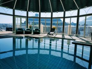 a swimming pool with chairs and a view of the mountains at APPARTEMENTS VINUALES in Lourdes