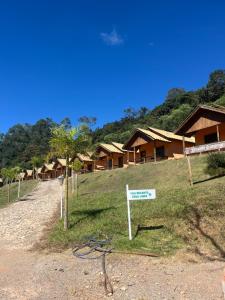 a sign in front of a group of houses at Hotel Fazenda Recanto in Ouro Branco