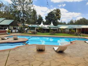 a pool with chairs and tables in a resort at Royale Health Club in Nairobi