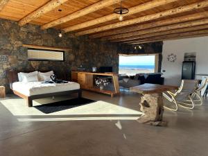 a bedroom with a bed and a table and a couch at Casita Tahona con vistas de infarto al mar y volcanes con absoluta privacidad in Parque Holandes