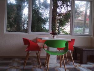 a table and two chairs in a room with windows at Diamond Hotel in Ureki