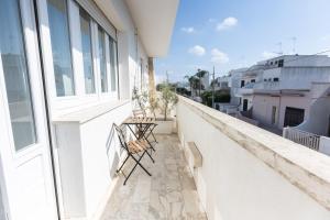 a balcony with chairs and a view of the city at NC Boutique B&B in Torre San Giovanni Ugento