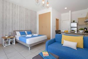 a bedroom with a bed and a couch at MERYL - Coralli Beachfront Apartment in Protaras