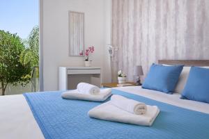 a bedroom with two beds with towels on them at MERYL - Coralli Beachfront Apartment in Protaras