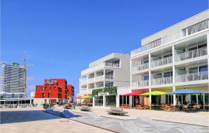 ein Gebäude mit Tischen und Sonnenschirmen davor in der Unterkunft Priwallpromenade 23, Whg 1 in Priwall